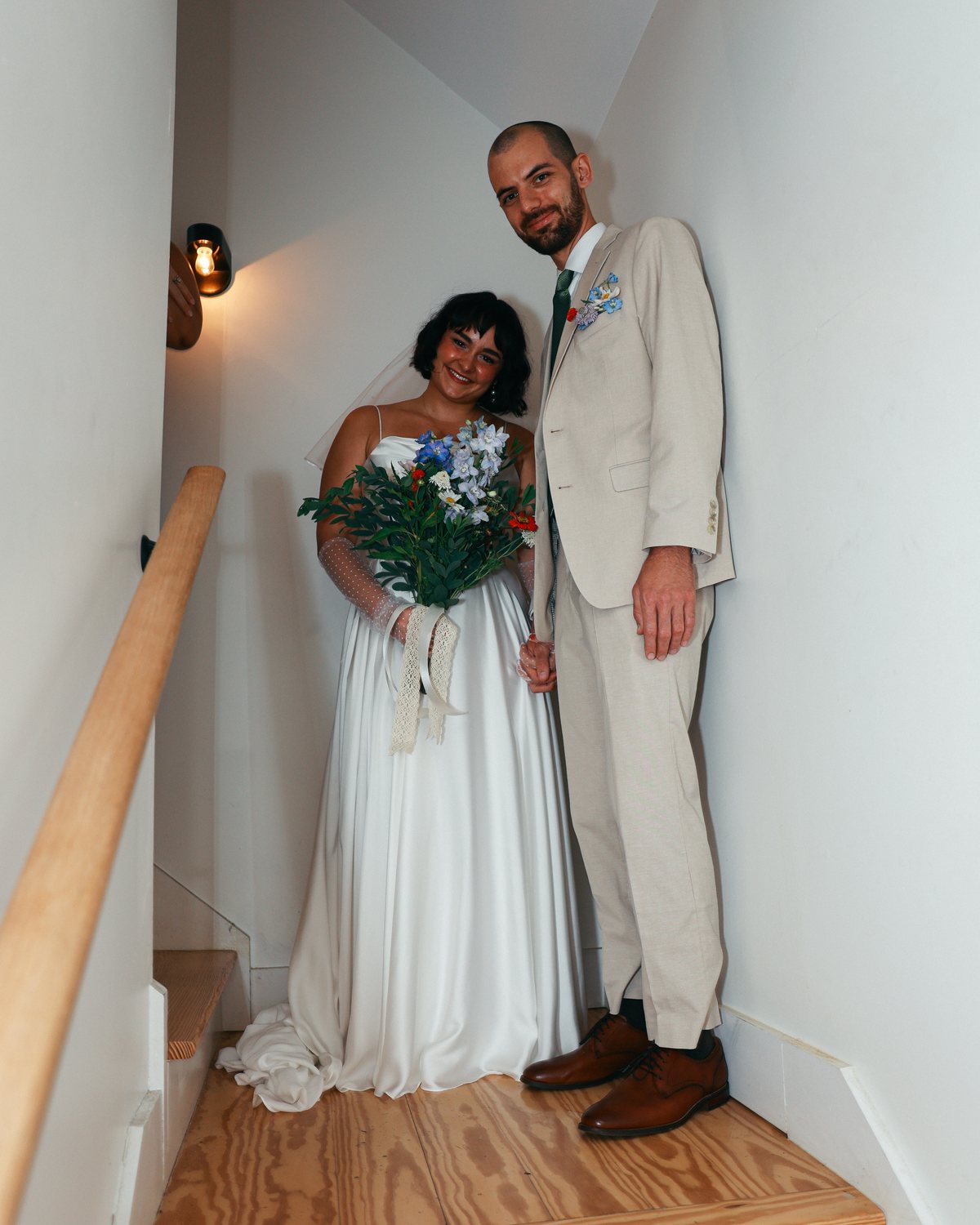 Grace Bryan and Matthew Barber on their wedding day, standing together on a stairway