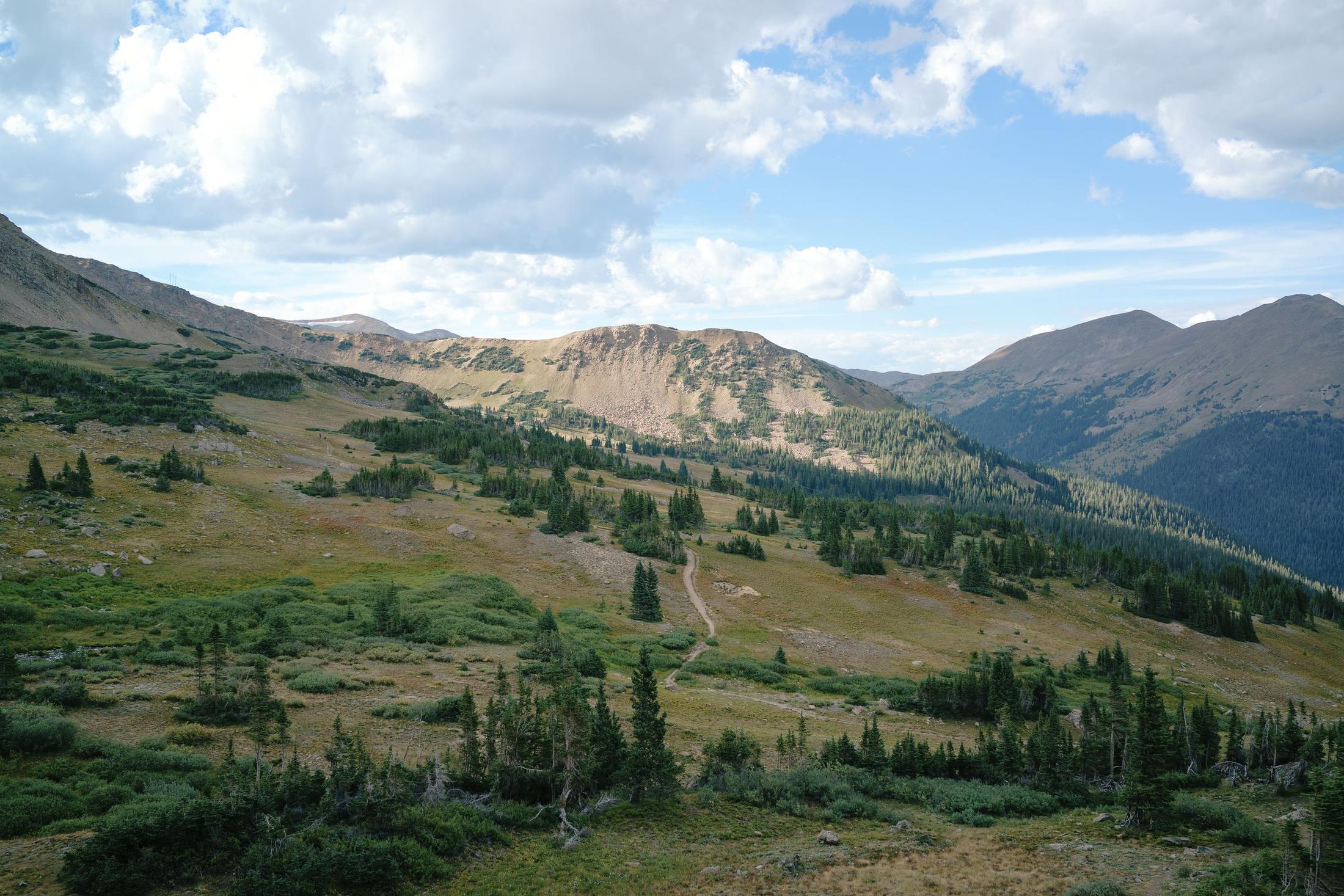 A trail winding through an alpine valley in the Colorado mountains